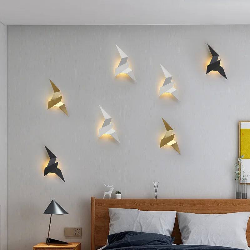 Eight origami bird wall lights mixed colours above bed bedroom decor